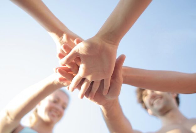 Hands stacking on top of each other in a group