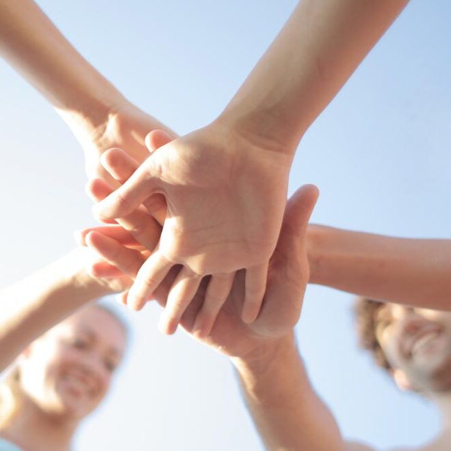 Hands stacking on top of each other in a group