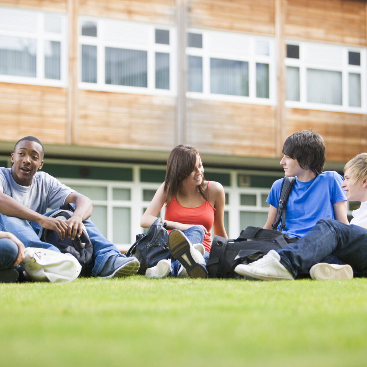 students sitting on grass